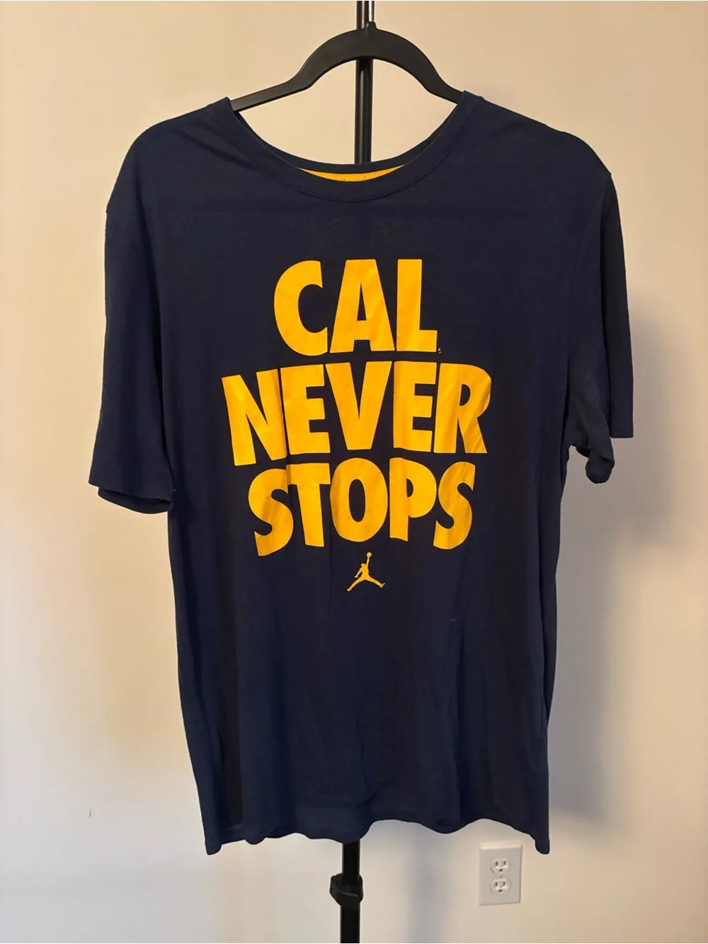 Jordan Men's Navy Blue Short Sleeve Tee with Yellow 'CAL NEVER STOPS' Graphic